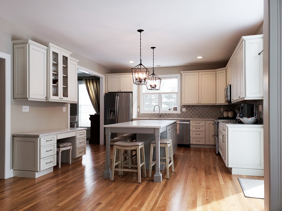 Renovated kitchen with white cabinetry, wood accents, and a large island